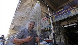دوش خیابانی برای مقابله با گرما در بغداد + عکسها
