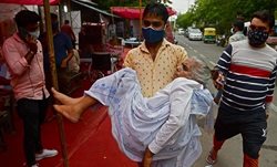 انتقال یک بیمار کووید 19 به بیمارستانی در دهلی + عکس