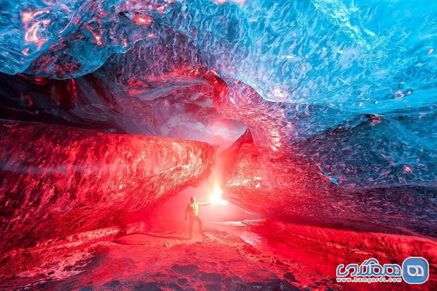 An ice cave in Iceland lit up with a flare 