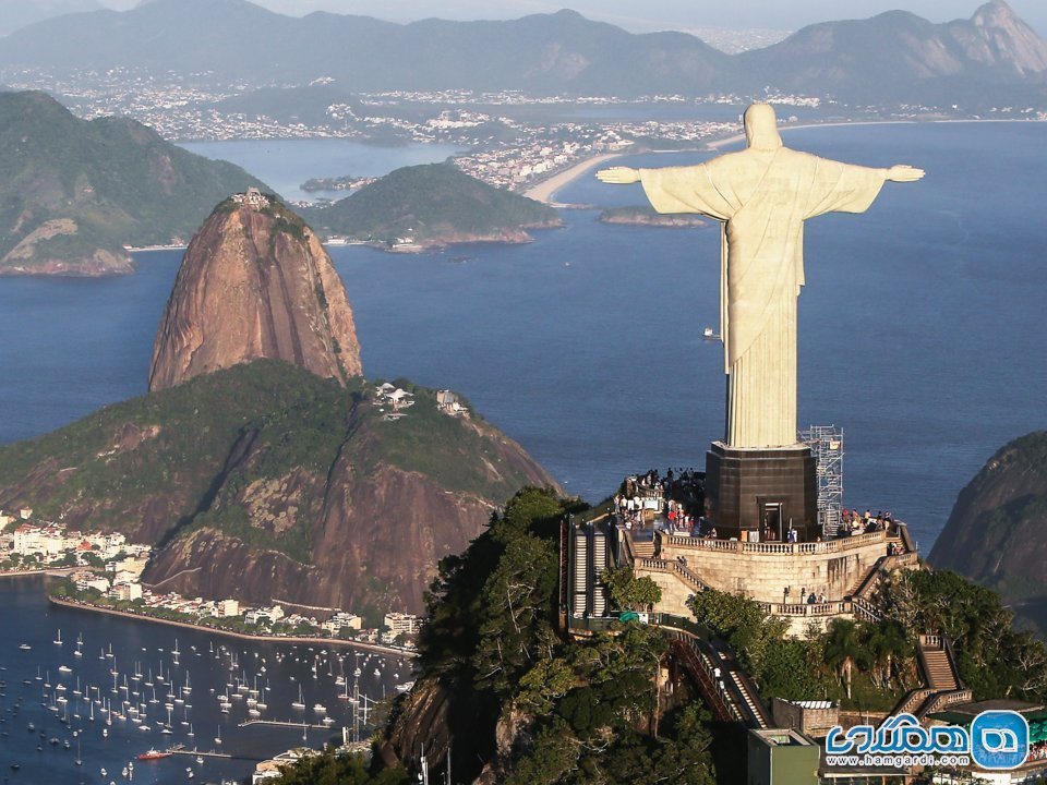 در ریودوژانیرو در برزیل، در کنار مجسمه مسیح بر بالای کوه کوکووادو عکس بگیرید